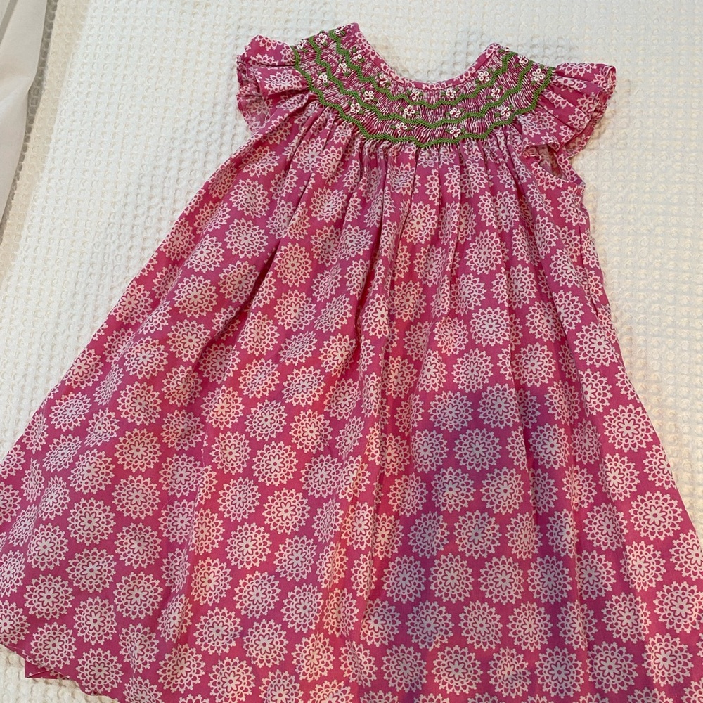 Smocked floral Bibb. GUC. Geometric pattern. Pink. Green. White.